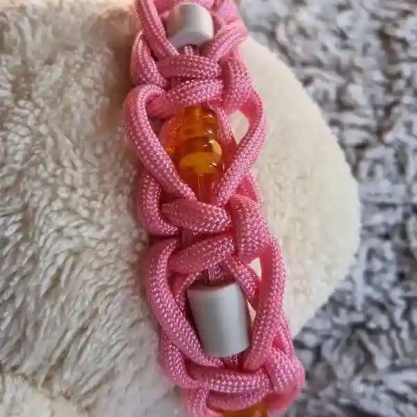 collier EM et ambre antipuces et tiques coloris rose le détail du tressage et des perles